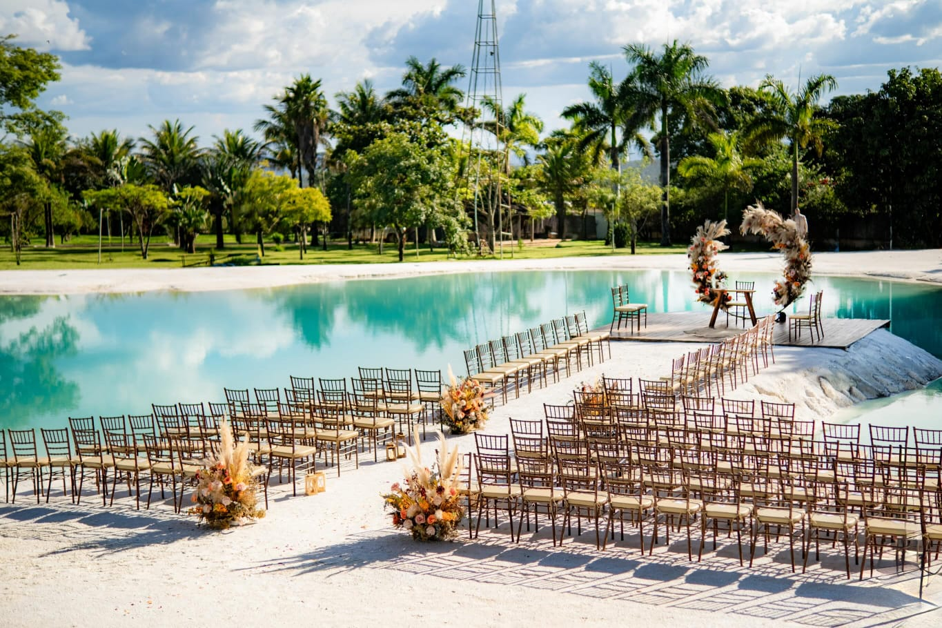 Vista do espaco do casamento com lago e cadeiras da cerimonia